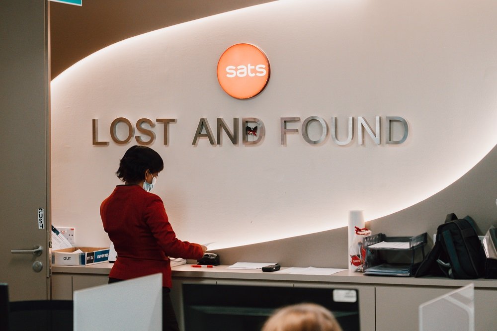 Airport lost and found counter with unclaimed bags and personal items